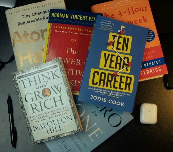 Atomic habits think and grow rich ten year career and other self help books on a table