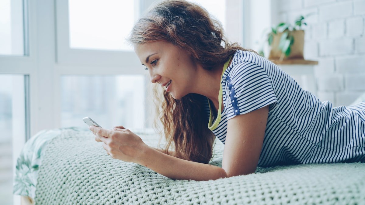 Person lying in bed reading on a phone screen at night