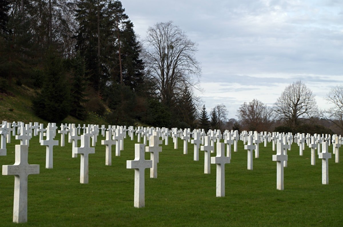 Rows of white cross gravestones on a green lawn, a WWI memorial