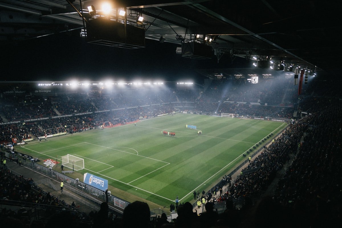 A soccer stadium packed with spectators under bright lights